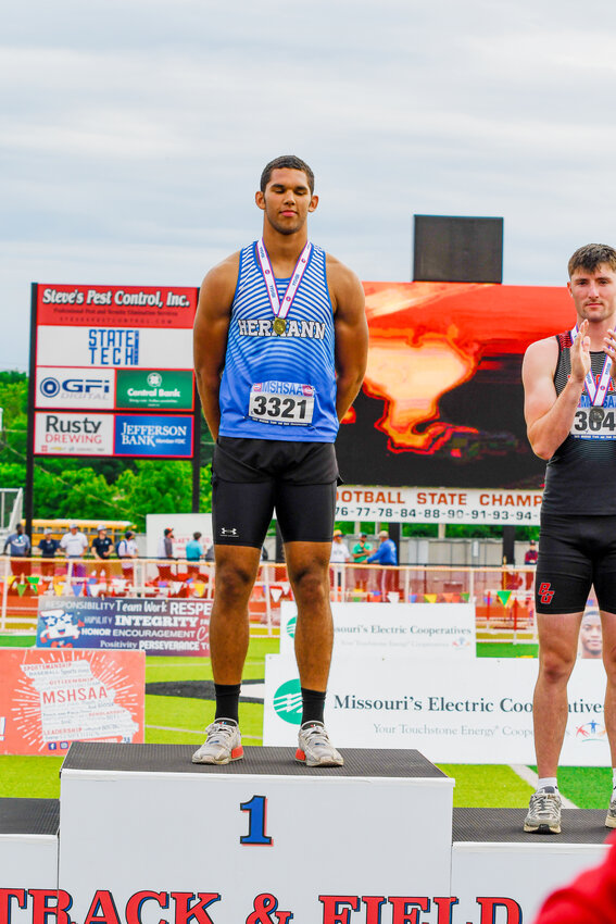 Daeden Hopkins (right) stands atop the medal stand as the state champion in the Class 3 Boys Javelin while Nolan Kopp occupies the seventh-place spot on the podium after his finish in the Boys Class 3 3200-meter run.
