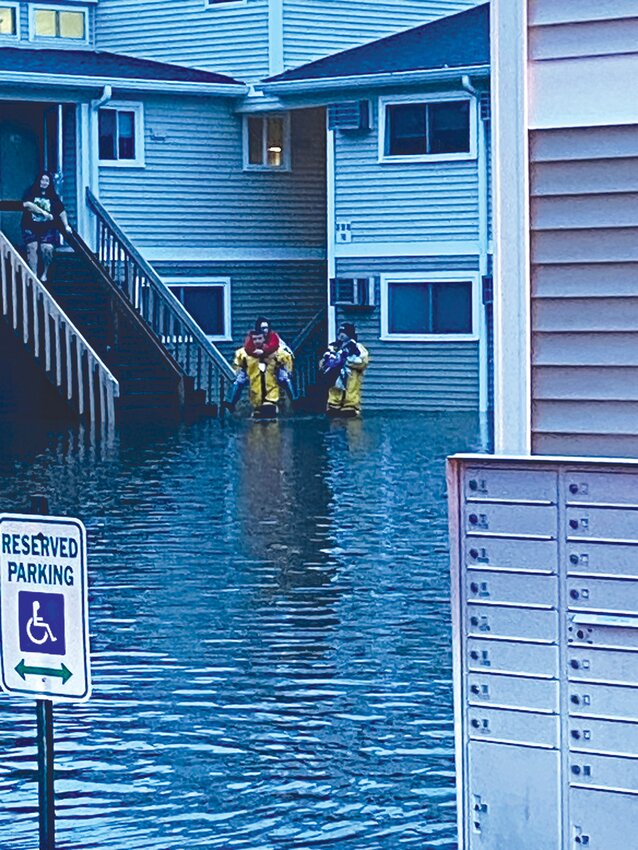 Johnston firefighters carry stranded residents from their apartments at Park Plaza after last January’s deluge. (Beacon Media files)