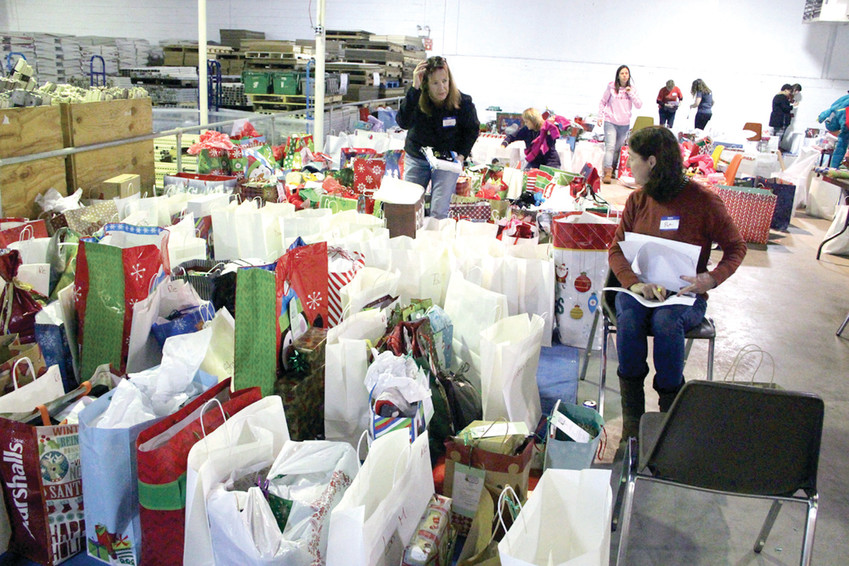 WHERE SHOULD THIS GO? Denise Murphy and Joan Larrivee look over gifts before matching them with requests.