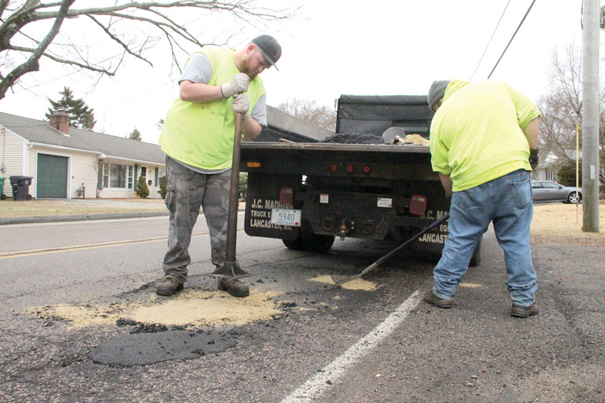 PATCH CREW: Swav Hermanowski and Chris St. Pierre fill potholes on Diamond Hill Road. Sand is used to cover the cold patch in an effort to reduce it from adhering to tires.