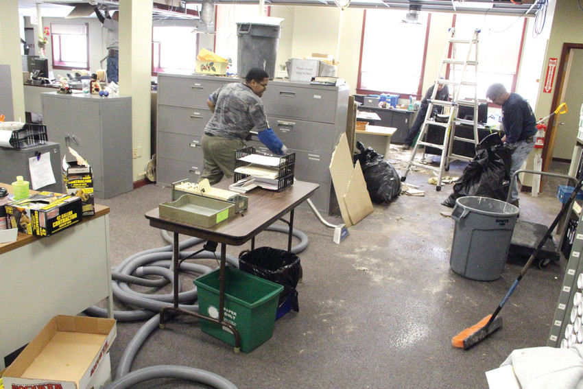 LEAKS IN CITY HALL ANNEX:  Crews mop up a waterlogged assessor&rsquo;s office after a burst water pipe forced the relocation of municipal offices in January.