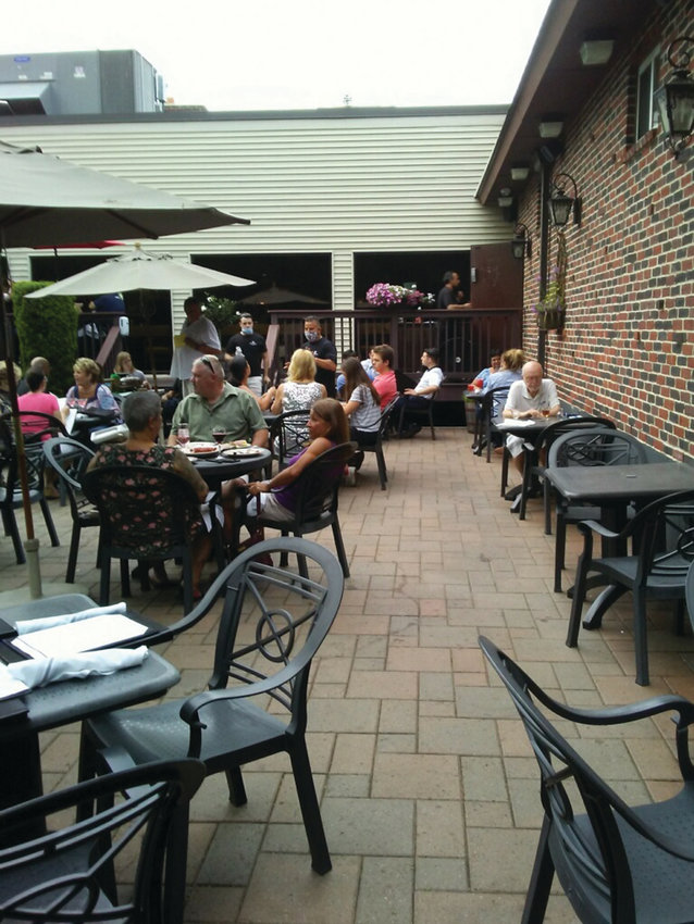 SPRING DINING: Patrons sit at tables on the outdoor patio at Twin Oaks.