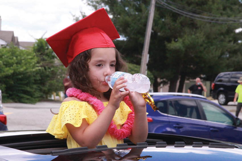 THAT&rsquo;S MOM&rsquo;S CAP: Mia Garcia takes a swig of water as she made the parade rounds wearing the cap her mother received as a Toll Gate grad.