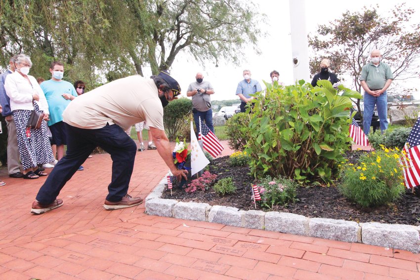 PLACING FLOWERS:&nbsp; Sal Caiozzo, commander of Chapter 9 of the Disabled American Veterans, places flowers during the service held at the 9/11 memorial.