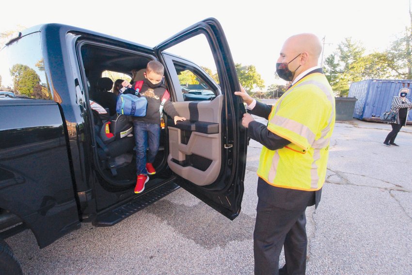 VALET SERVICE: Wyman School principal Ron Celio welcomes kindergartener Xander Simas to the first day of in-person school.