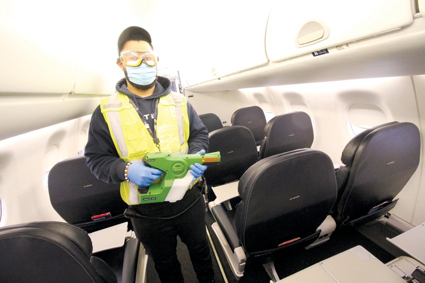 A CLEAN SWEEP: Using an electrostatic spray gun, Luis Fray demonstrates how he cleans a United jet in preparation for a flight later in the morning.