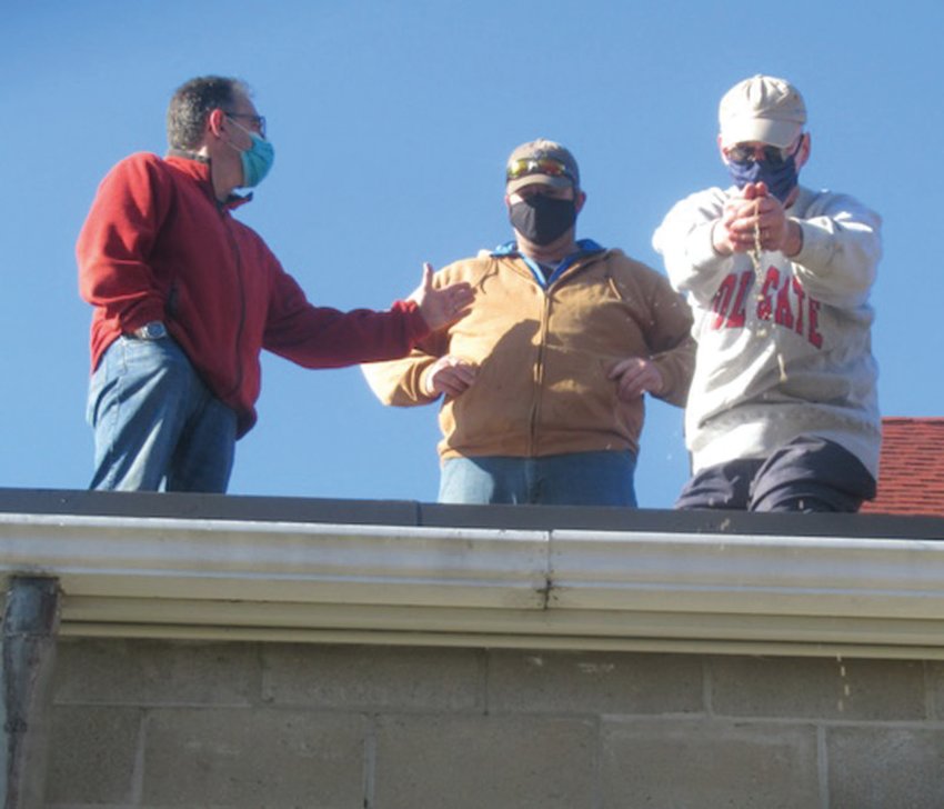 CLOSER TO GOD: St. Barnabas Episcopal Church parishioners Joseph Rodrigues (left), Paul Schofield (center) and Stanley Schofield used a unique number ways to remove leaves from the once clogged up rooftop gutters.