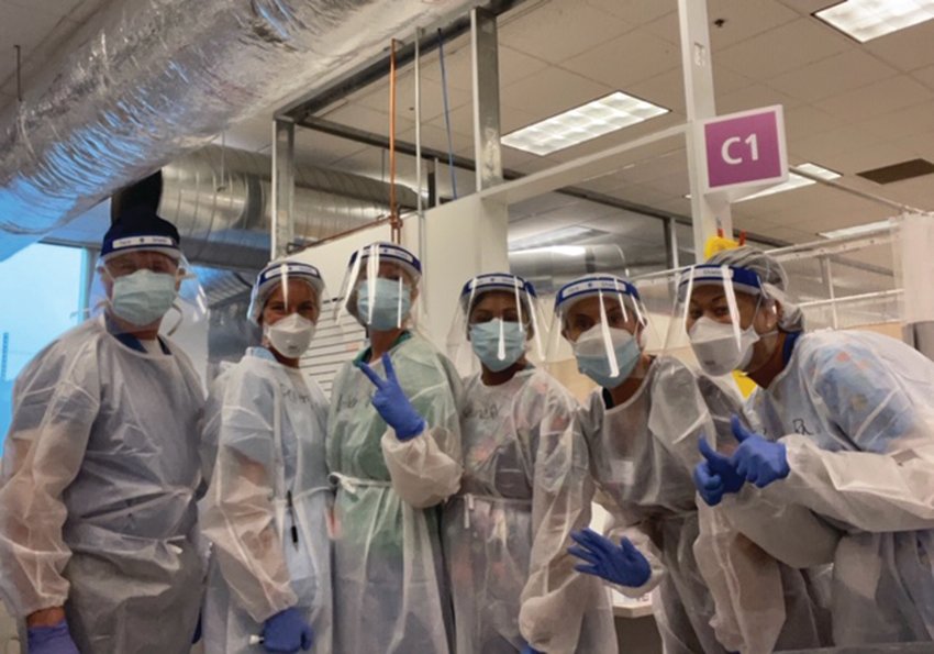 READY TO STEP IN: Dr. Herbert Brennan and the staff at the Cranston field hospital operated by Care New England gather for a group photo before the beginning of their 12-hour shift this past weekend.