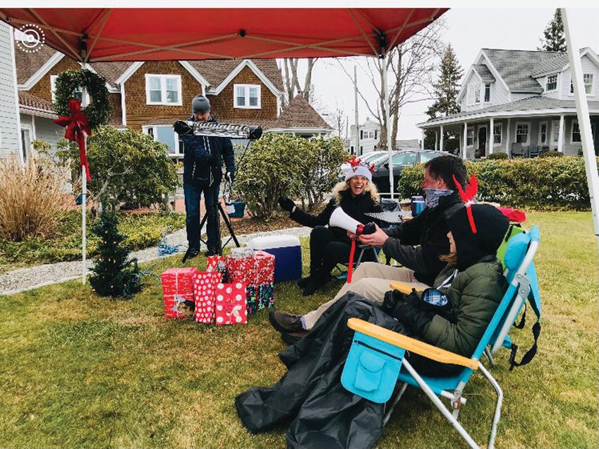 CHRISTMAS AFTER CHRISTMAS: John DeCesare, Rhea Harkins, and Addy DeCesare set up the Christmas scene, using the wreath from their front door and the top of an artificial Christmas tree, in under a minute. Neighbor Jack Hogan, in the background, arrived with a heating lamp.