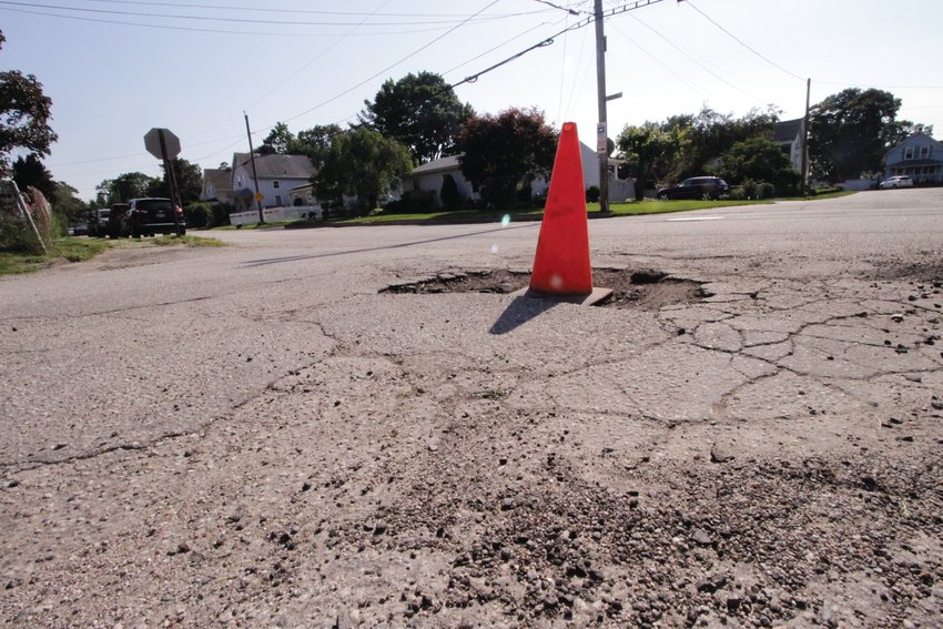 HALF THE STORY: Frederick Street and Budlong Avenue in Norwood, which had one lane of travel repaved after National Grid replaced gas mains, are not slated for complete repaving at this time. Meanwhile, a cone marks a pothole at the intersection of the two roads.