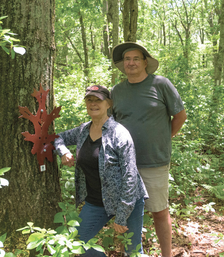 ON THE TRAIL: Doug Doe and Angie Koziara of the West Bay Land Trust pose with one of the plant life-inspired &ldquo;creatures&rdquo; along a trail in Cranston. (Submitted photo)