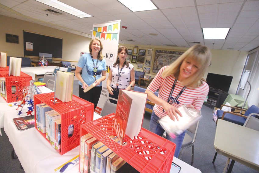 POP-UP LIBRARY: Librarians Jen Linton, Kelly DiCenzo and Ellen O&rsquo;Brien operated at pop-up library from the Pilgrim Senior Center for the reopening party held Friday.