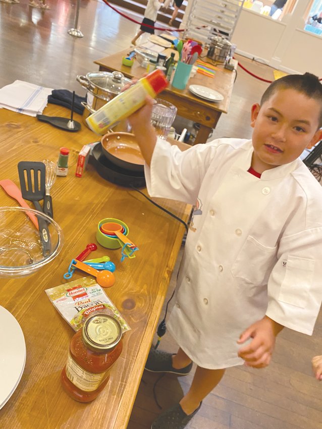 TINY CHEF, BIG APPETITE: Colin Yick, age 8, explains the importance of using cooking spray when making a snack pizza.