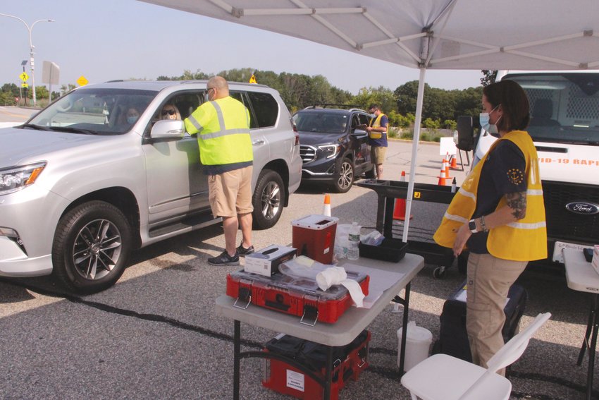 FIRST STOP: As motorists arrived at the drive-thru vaccination clinic, they were given forms to complete that were handed off at the next stop where they received their vaccination. At a third and final station they were given a vaccination card and given an appointment for a second shot, if required.