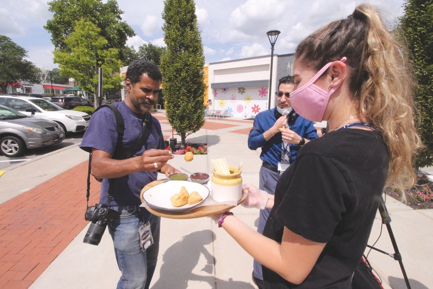 A SNACK: Caroline D&rsquo;Amico passes out food from Chaska to the media including Journal  photographer Kris Craig.