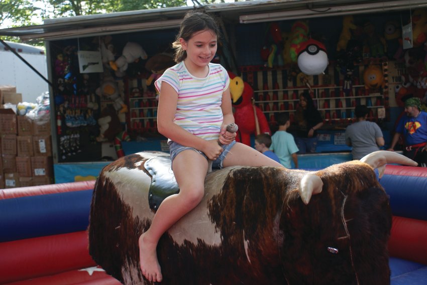 HOLD ON TIGHT: Zayleigh Falkowski, 10, rode the bull at this past weekend&rsquo;s Gaspee Day Arts &amp; Crafts Festival. She was able to complete the entire ride.