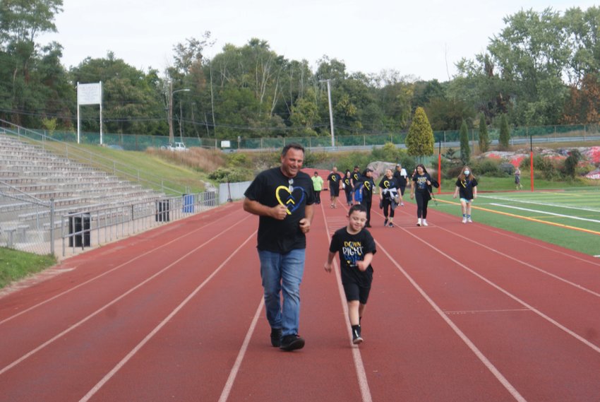 MAKING THE ROUNDS: Vincenzo Feole, an 8-year-old boy from Cranston with Down syndrome, took part in the Buddy Walk with his father, Steve Feole.