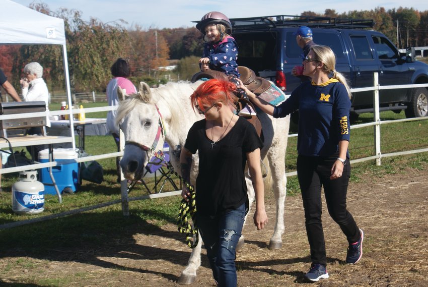 GIDDY UP! Enjoying her time on a pony named Cloud at Jocks Horse Farm was Alessandra Lenz, 3. Her mother, Ashley, walked beside her as Katie McCormick led the horse.