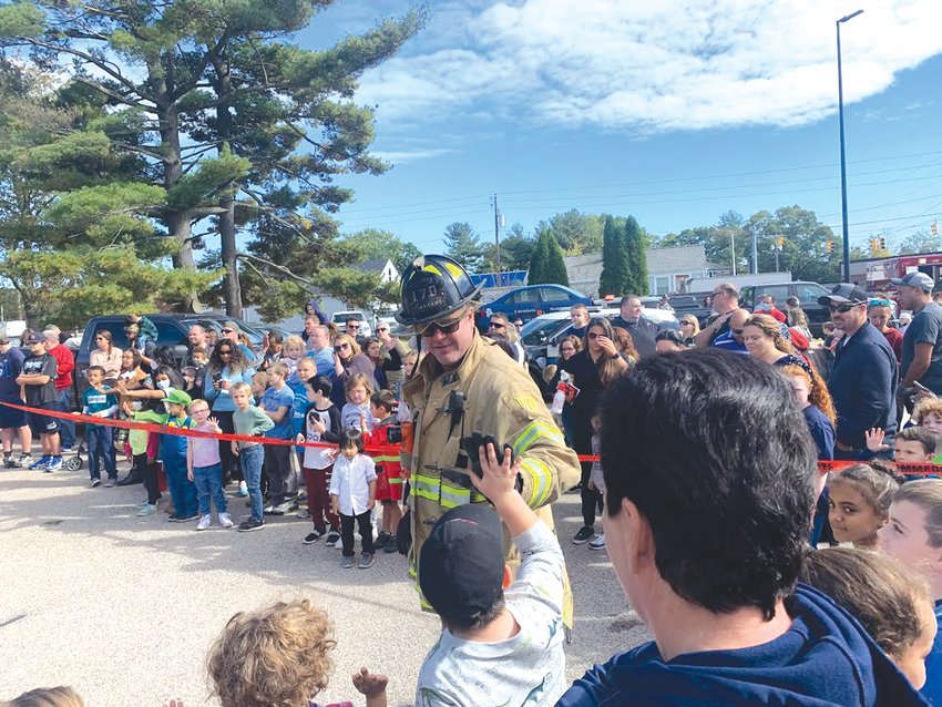 CELEBRATING: After fire fighters completed the Jaws of Life demonstration children  who were gathered around to watch congratulated the firefighters on a job well done by giving them high fives.