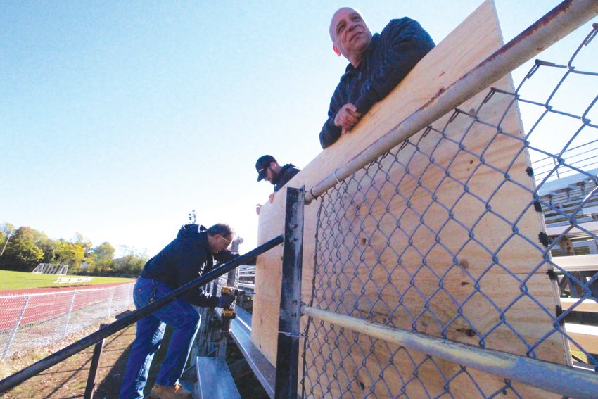 CLOSED FOR NOW: A School Department crew of Joe Pisaturo, Matt Dailey and John Ricci affix sheets of plywood to close off the Pilgrim High School bleachers.