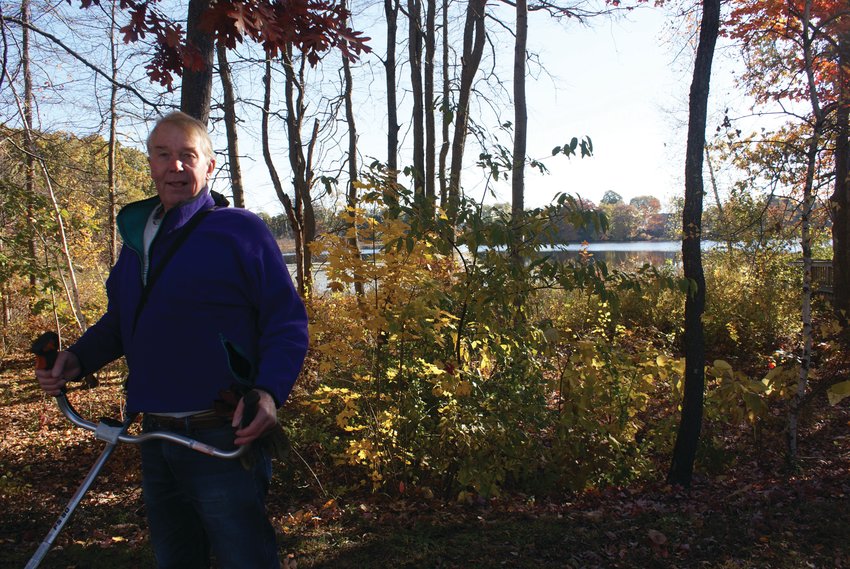 IN THE WEEDS: Cleaning up the leaves at Randall Pond this past Saturday was volunteer Paul Lockett this past Saturday morning.