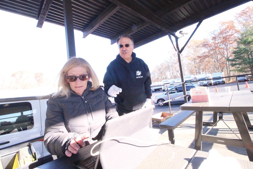 CHECKING OFF ORDERSB: Kate Upham checks orders as Harry Waterman relays the information to a team of Rocky Hill Country Day students who loaded boxes of grapefruits, oranges, pear and apples into cars.