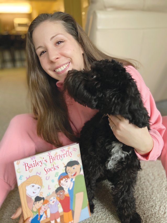 A HANDFUL: Mikayla Rogers with her book and her dog, Scamp. Rogers&rsquo; pen name is &ldquo;Mikayla Joy,&rdquo; which is her first and middle names.