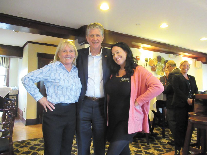 HAPPY HOSTS: Laurie O&rsquo;Rourke (left), owner of O&rsquo;Rourke&rsquo;s Bar &amp; Grill in Pawtucket Village and mixologist Amy Chaffee are all smiles as they welcome Gov. McKee.