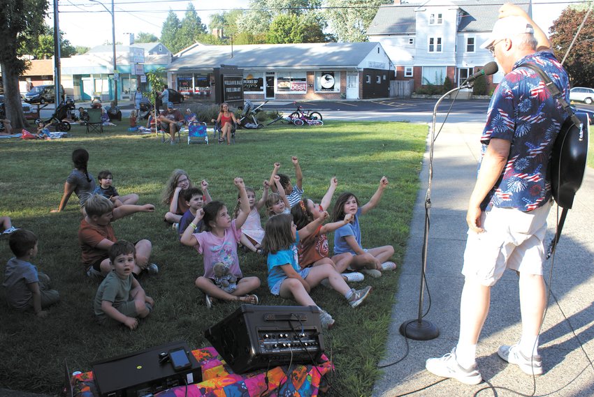 GUITAR AND GAMES: To the delight of all in attendance, T-Bone, (Tom Stakus), sang songs, played the guitar and ran games during his show at the Hall Library.