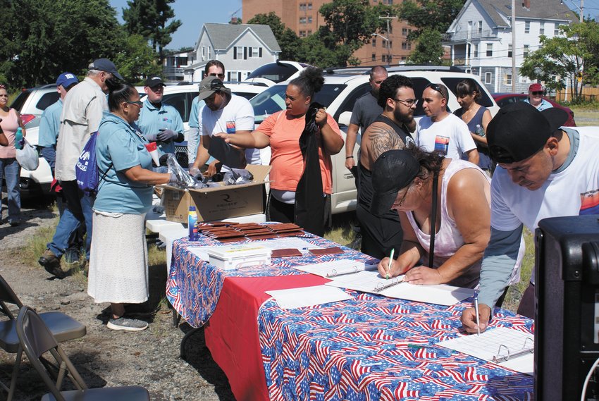 SIGNING UP: Just some of the approximately 60 volunteers are seen at the sign-up table registering to help.