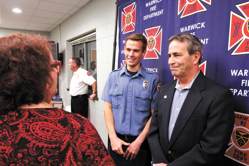 ACTIONS APPLAUDED: Captain Andrew Sisson, center, talks with Rep. Camille Vella-Wilkinson and Mayor Picozzi following presentation of a resolution recognizing his actions on Oct. 15 while off duty that is credited in helping save the life of a surfer off Little Compton. (Warwick Beacon photo)