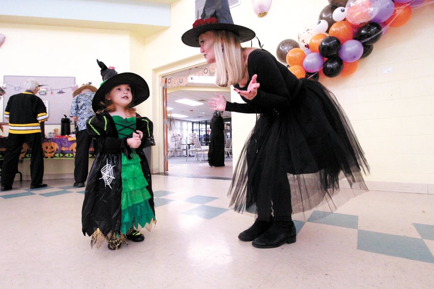 LITTLEST WITCH: Kennedy Woodbine, 3, puts her spell on senior center director  Meg Underwood.