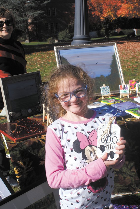 FESTIVE FALL SIGN: Cranston resident Mikayla Guatieri, 5, of Stadium Elementary School stopped by the arts and crafts fair where she got a Halloween sign from local vendors.