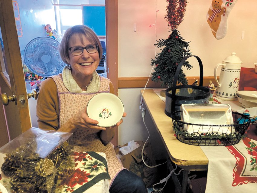 CHRISTMAS TREASURES: Barbara Spencer, the minister&rsquo;s wife, assisted shoppers in finding just the right item to take home. Among some of the kitchenware were holiday dishes with snowmen.