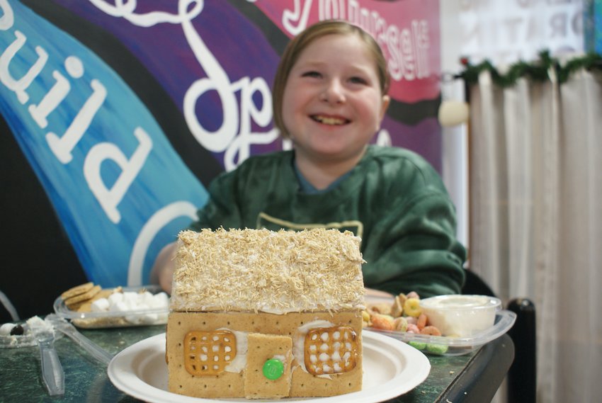 FIRST TO ARRIVE: Ten-year-old Avery Bouvier was the first person to arrive at the Artists&rsquo; Exchange gingerbread house decorating contest. She crushed up wheaties to create a thatched roof for her creation.