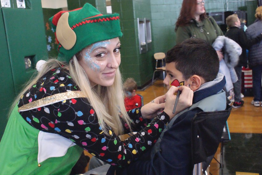 FACE PAINTING: Lindsay Carey-Asquith paints Chace Azevedo&rsquo;s, 8, face at the Bolts Bazaar on Dec. 10.