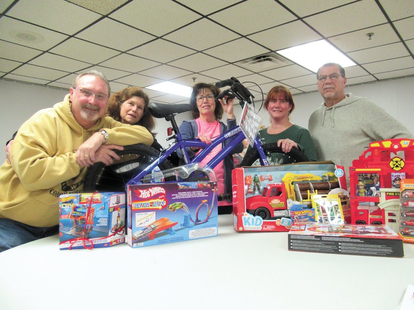 HAPPY HELPERS: These Tri-City Elks are all smiles standing an example of the overflow foods and toys collected for families in need, are from, left: Mike Marsh, Jen Jacobs, Carol DeLory, Debbie Boulay and Joe Grimaldi.