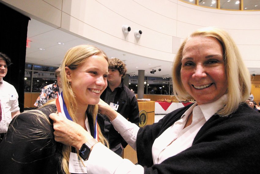 BESTOWING THE HONORS: Cranston Senator Hannah Gallo, a teacher herself and an advocate of the academic decathlon, participated in the awards ceremony held Sunday evening at Bryant. Here she awards a medal to Olivia Tedeschi-Man.