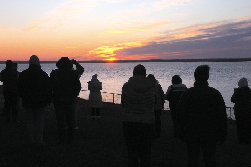 FIRST LIGHT: Rising above the Bristol shoreline, the sun cast its rays on those who attended the Easter morning service conducted by five Warwick churches at the Warwick Neck lighthouse.