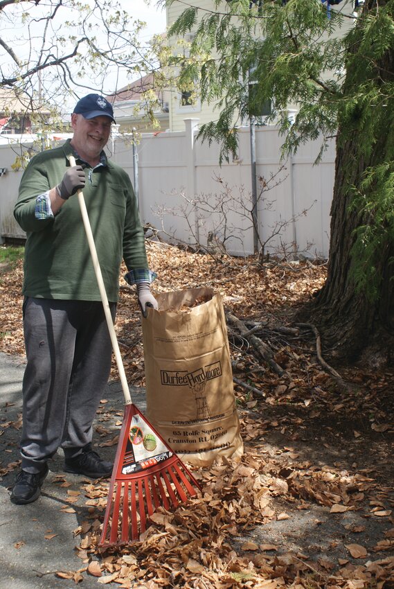 RAKING IT IN: Cemetery Commission Chairman Dave Guiot pitches in other volunteers to help clean up the manor grounds by raking leaves.