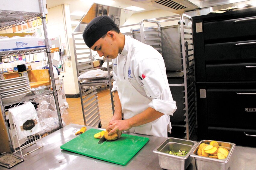 SLICED THIN: Warwick Area Career and Technology culinary student Shane Giroux cuts potatoes that were part of the school&rsquo;s entry in the High School Seafood Cookoff held Thursday at the center. (Warwick Beacon Photos)