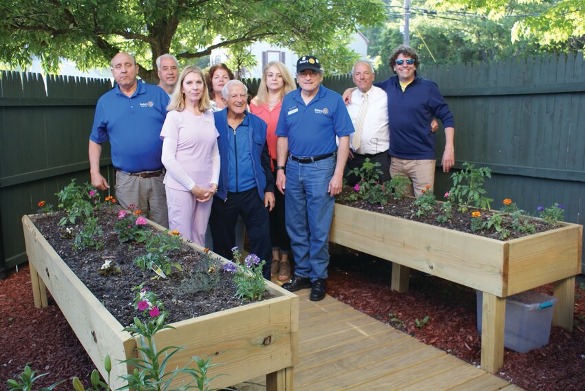 JOB WELL DONE: Rotary members show off the new planters and boardwalk the built for the Adult Day Services Center with the center&rsquo;s director, Rosemary Coren (in pink).