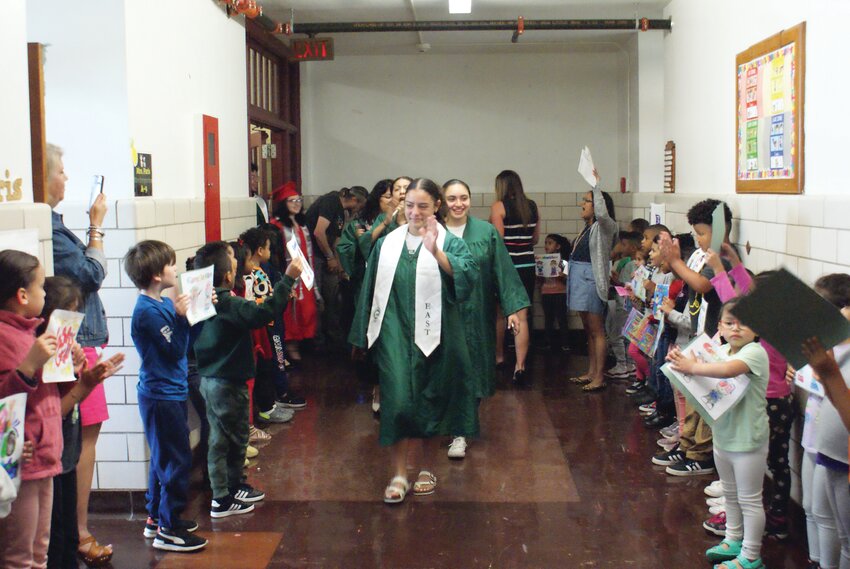 GLAD TO BE BACK: Students from Cranston East walk the halls of Gladstone Elementary as they are cheered on by current students of the school Gladstone elementary.