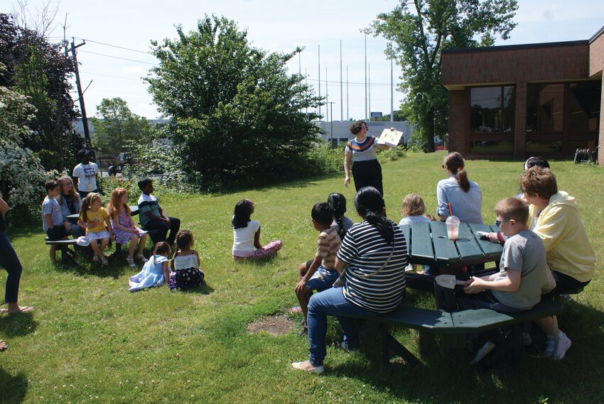 CURIOSITY IN BLOOM: Librarian Elise Petrarca reads a book to the children to get them excited to begin their gardening project.