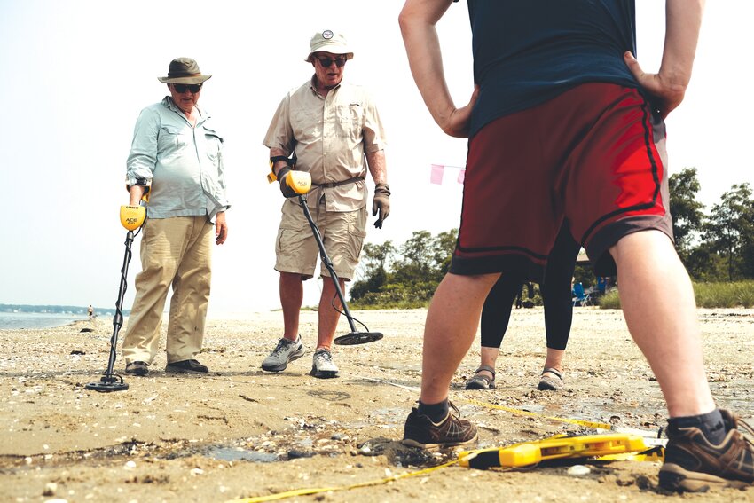 SANDY SEARCH: Assisted by &ldquo;moon low tides&rdquo; Rhode Island Marine Archaeology Project volunteers extended their hunt for remnants of the Gaspee to the northwest end of Gaspee Point this week both on land and below water. Here they prepare to do a metal detector scan after mapping out a grid of the area. Story and more photos on Page 3. (Warwick Beacon photo by Will Steinfeld)