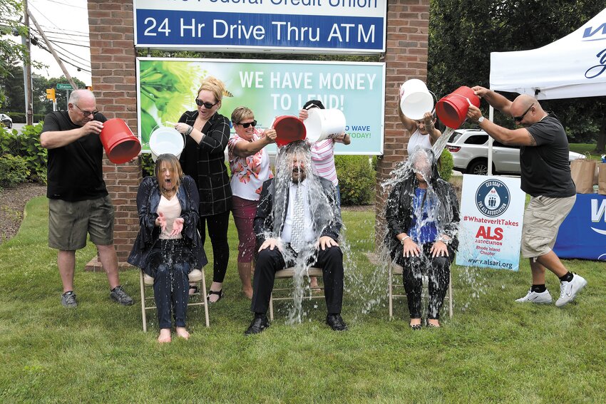 GETTING DOSED: (left to right front row) Elizabeth L. Zachow, VP of Lending, David P. Dup&eacute;re, President/CEO, Betty A. Pinheiro, VP of Operations.(back row) Wave CEO Soak Team