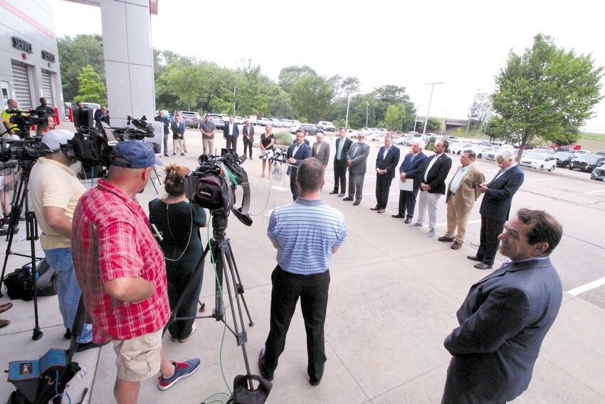 IT&rsquo;S GOING TO COME DOWN:  The Route 37 ramp over Post Road, now supported by wooden &ldquo;logs&rdquo; that looked to be swayed under the load, will come down and replaced by an at-grade intersection. Derek Torrey from the Federal Highway Administration addresses the July 21 press conference at Balise Auto to announce a federal $25 million grant enabling the project. (Warwick Beacon photos)