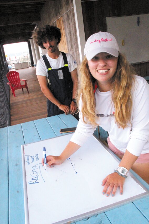 SETTING A COURSE: EYC sailing instructor Greta Shuster draws a course and sets the timing to start a race for the more experienced sailors at the school. (Cranston Herald photos)