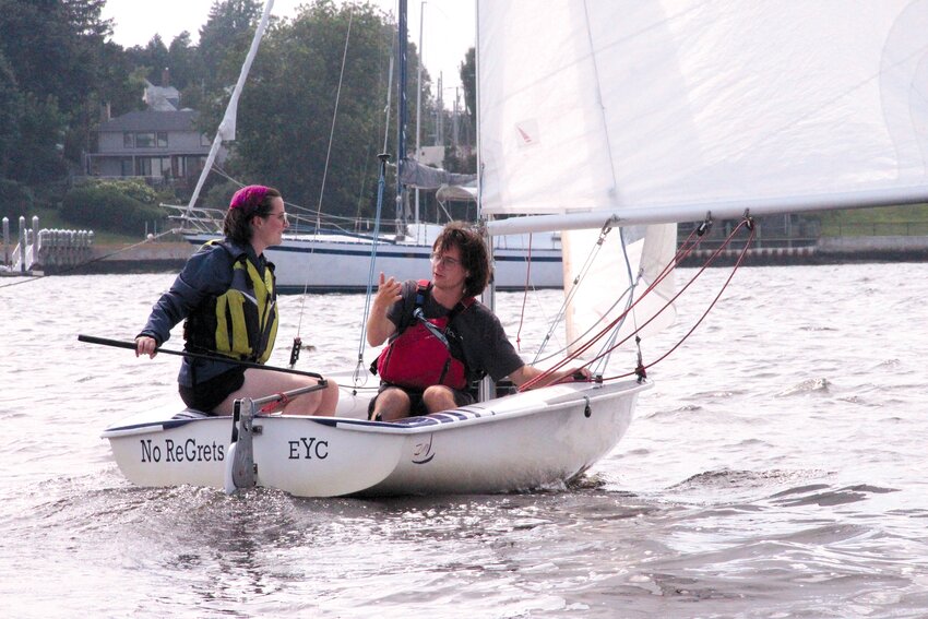 IN CONTROL: Brown student and summer intern at Beacon Communications, Dana Richie, tiller in hand, makes her maiden sailing outing under the guidance of Edgewood Sailing School instructor  Alex Stepanov. As the boat is named, she had no regrets although she came close to swimming. (Cranston Herald photos)