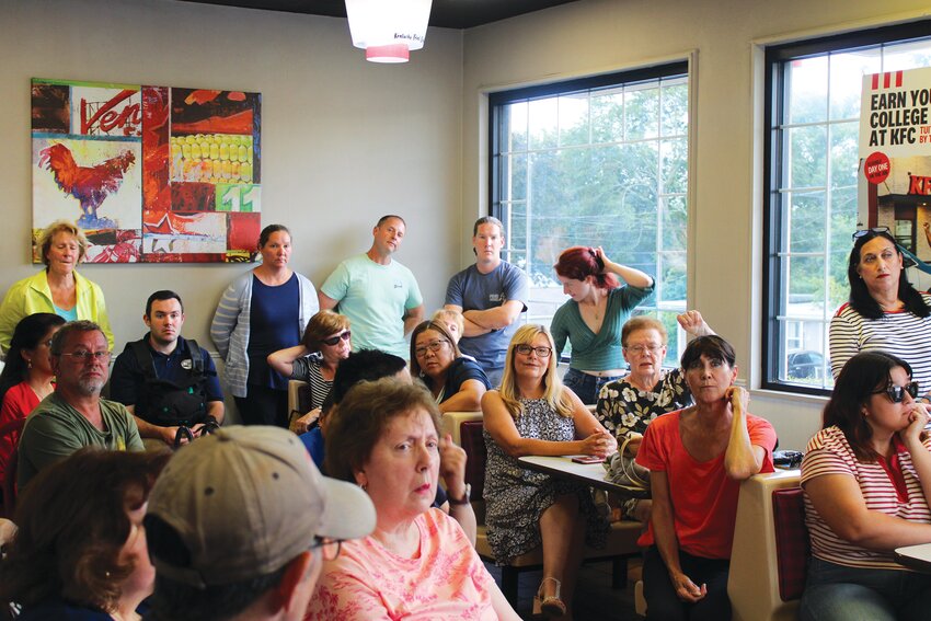 NEIGHBORS UNITED: A group of almost 40 neighbors who live behind the KFC on Reservoir Avenue pack into the restaurant&rsquo;s small dining room ready to hear what the new owners have planned and how it may affect their lives. (Herald photo by Ed Kdonian)